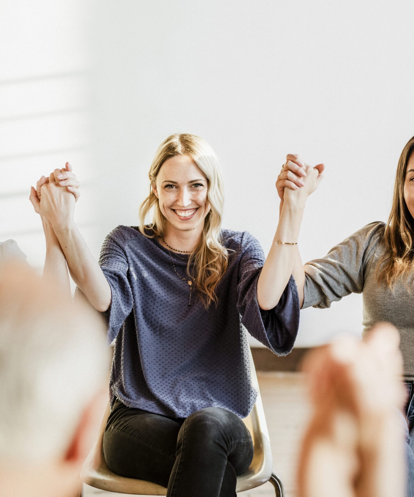Group of diverse people holding hands up in the air